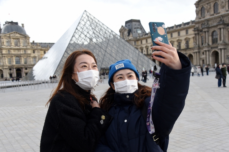 Des touristes chinoises devant la pyramide du Louvre à Paris, en janvier 2020.